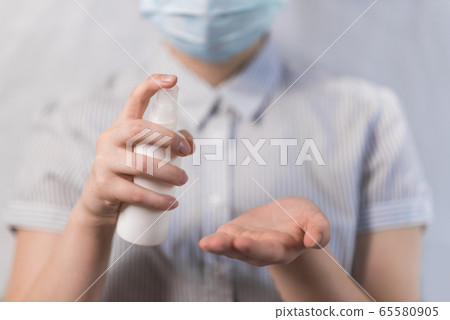 Close-up, teenage girl holding a spray bottle with an antiseptic, disinfection and sanitization, disinfection with bactericidal compound viruses, stay home, disease prevention disease protection. 65580905
