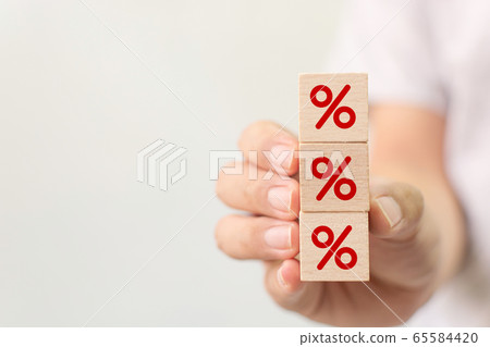 Hand holding wooden cube block increasing on top with icon percentage symbol upward direction Hand holding wooden cube block increasing on top with icon percentage symbol upward direction 65584420