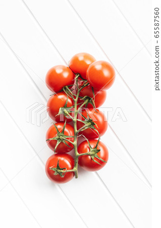 Branch of red cherry tomatoes. 65587560