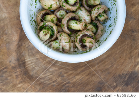 in a bowl raw mushrooms champignons in a marinade with herbs, dill in a rustic natural form. View 65588160