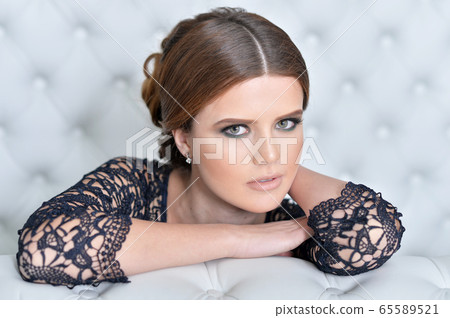 Portrait of beautiful young woman in bedroom Portrait of beautiful young woman in bedroom 65589521