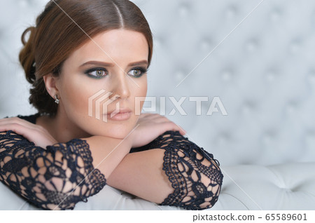Portrait of beautiful young woman in bedroom 65589601