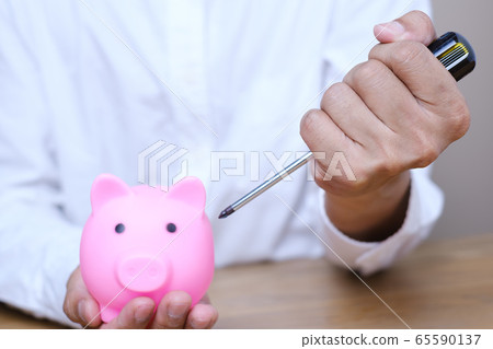 Emergency finance and Reserve money concept, Businessman using tools to destroy pink piggy bank Emergency finance and Reserve money concept, Businessman using tools to destroy pink piggy bank 65590137