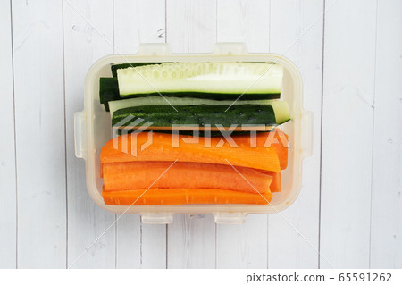 Fresh carrot and cucumber sticks in a container. Centimeter measurement of volume. Concept of dietary nutrition. Copy space. Fresh carrot and cucumber sticks in a container. Centimeter measurement of volume. Concept of dietary nutrition. Copy space. 65591262