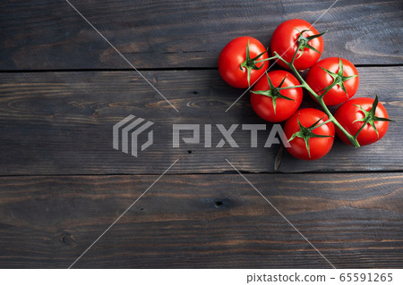 Cherry tomatoes on a branch. Fresh juicy red tomatoes on a dark wooden background. Copy space. Cherry tomatoes on a branch. Fresh juicy red tomatoes on a dark wooden background. Copy space. 65591265