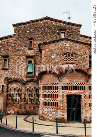 Red brick vintage building of Ca l'Ordal in La Colonia Guell in Barcelona 65592128