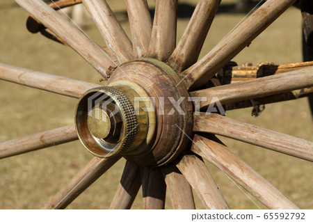 old wooden wheel and sulky bronze in the field 65592792