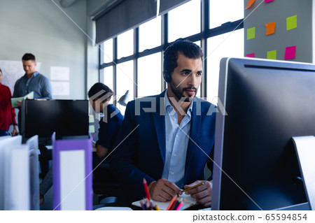 Caucasian man working with headset phone in office Caucasian man working with headset phone in office 65594854