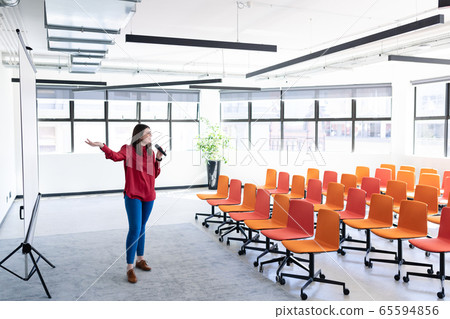 Caucasian woman training herself in a conference room Caucasian woman training herself in a conference room 65594856
