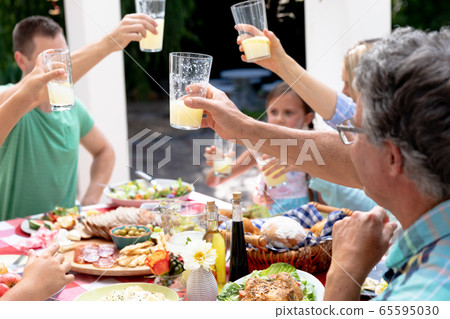 Caucasian family sitting at table during a family lunch in the garden 65595030