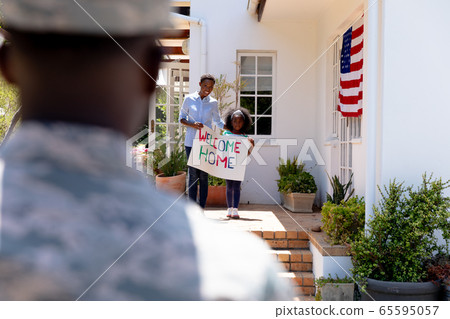 African American woman and her daughter standing welcoming an African American soldier African American woman and her daughter standing welcoming an African American soldier 65595057