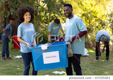 Multi-generation people collecting garbage with a couple holding a box written Donation Multi-generation people collecting garbage with a couple holding a box written Donation 65595061
