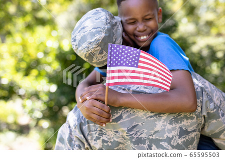 African American man wearing a military uniform holding his son African American man wearing a military uniform holding his son 65595503