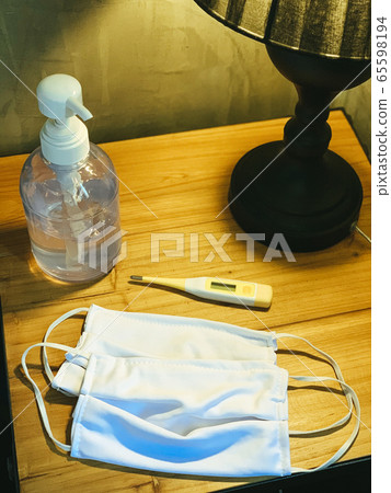 Coronavirus prevention medical surgical masks, hand sanitizer gel and thermometer on wooden table. Personal Hygiene concept Coronavirus prevention medical surgical masks, hand sanitizer gel and thermometer on wooden table. Personal Hygiene concept 65598194