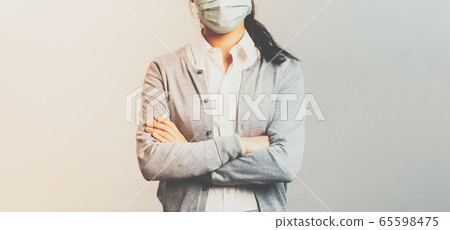 Covid19, virus, health and medicine concept. Portrait of young professional asian employee work on remote, staying safe, wear medical mask, cross hands over chest confident serious looking 65598475