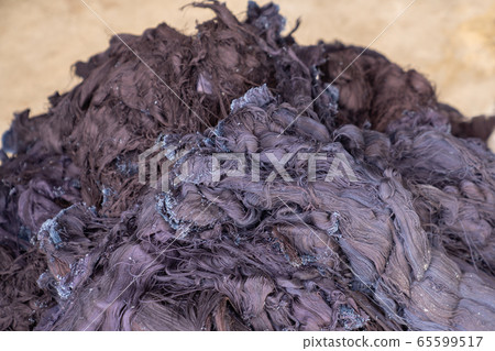 Fabric scraps, old clothing and textiles are cut into strips waiting for recycle. Fabric scraps, old clothing and textiles are cut into strips waiting for recycle. 65599517