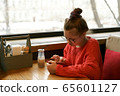 Girl teenager sitting in a cafe at a table waiting  65601127