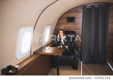 Attractive woman in private jet 65602348