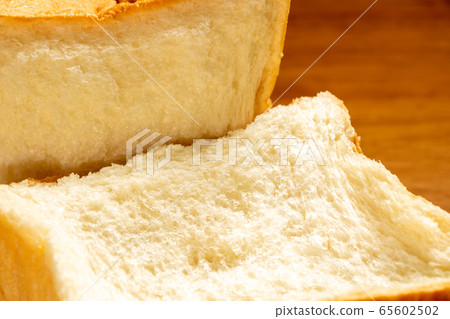 Square shaped bread broken by hand. 65602502