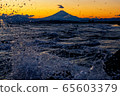 Mt. Fuji and waves splashed in orange at sunset 65603379