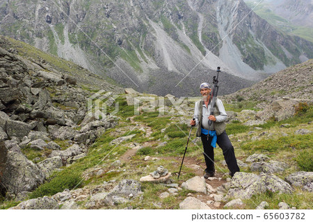 Male tourist climbing the mountains Male tourist climbing the mountains 65603782