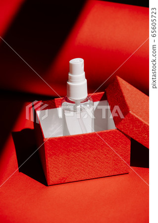 Post-Covid New Normal concept with Alcohol hand Sanitizing Spray as gift in red gift box. How Will Things Change In Post Pandemic World 65605723