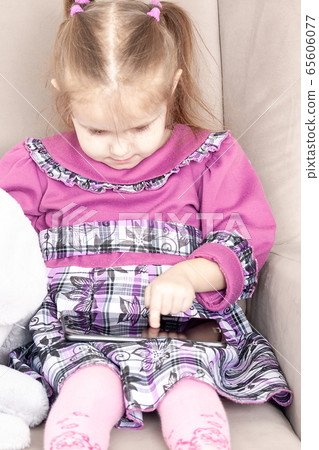 little girl in a purple dress sits at a table and little girl in a purple dress sits at a table and 65606077