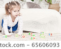 a little three-year-old girl plays cubes on which 65606093