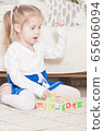 a little three-year-old girl plays cubes on which 65606094