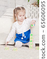 a little three-year-old girl plays cubes on which 65606095