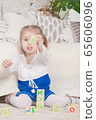 a little three-year-old girl plays cubes on which 65606096