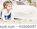 a little three-year-old girl plays cubes on which 65606097