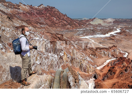 White tourist in medical mask takes photos. White tourist in medical mask takes photos. 65606727