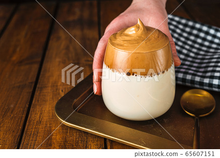 Woman's hand holding a glass of whipped instant Woman's hand holding a glass of whipped instant 65607151