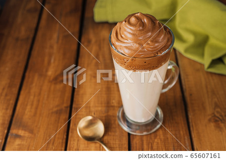 A long glass of delicious whipped Dalgona Coffee A long glass of delicious whipped Dalgona Coffee 65607161
