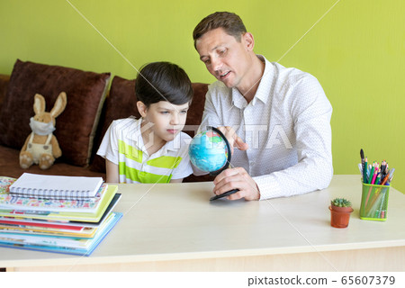 Boy with father doing homework during the coronavirus quarantine. 65607379