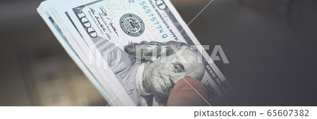 Close up dollars, hand holds bundle banknotes 65607382