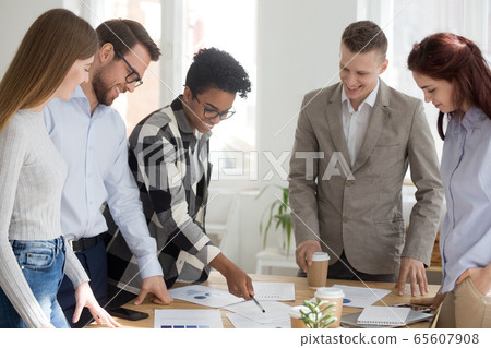 Happy diverse team brainstorm in office with papers on table 65607908