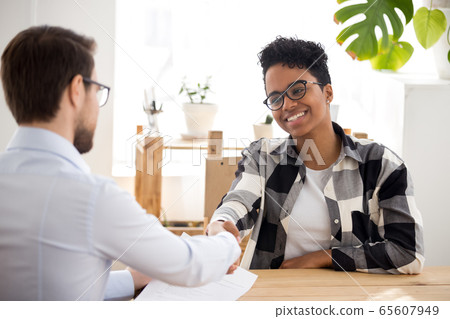 Happy confident african applicant shaking hand of hr getting hired 65607949