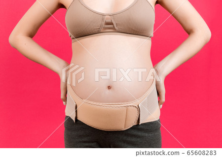 Close up of pregnant woman with supporting bandage Close up of pregnant woman with supporting bandage 65608283