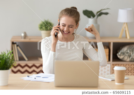 Happy girl excited hearing good news talking on phone Happy girl excited hearing good news talking on phone 65609115