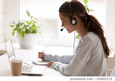 Concentrated millennial mixed race woman listening educational webinar. 65609122