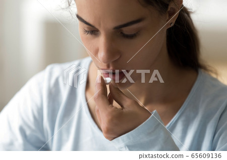 Millennial lady taking vitamins medicine, antidepressant, painkiller. Millennial lady taking vitamins medicine, antidepressant, painkiller. 65609136