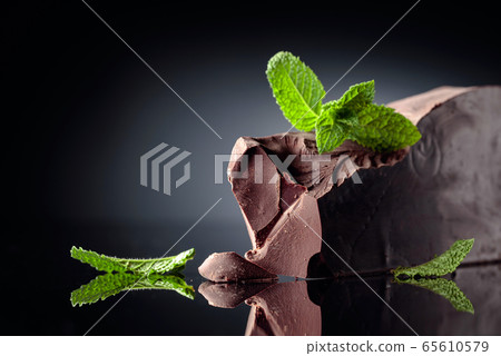 Large piece of dark bitter chocolate with mint on 65610579