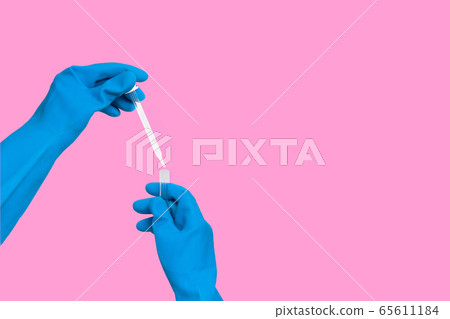 Hand in glove with dropper into test tube 65611184