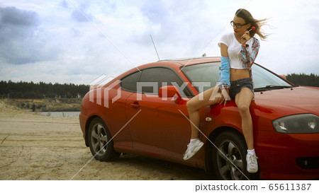 gorgeous blonde in glasses sits on a red car with gorgeous blonde in glasses sits on a red car with 65611387