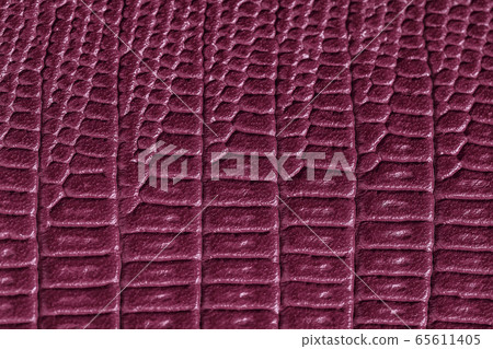 Texture of genuine leather close-up, embossed under the skin of reptile, burgundy color, fashion background 65611405