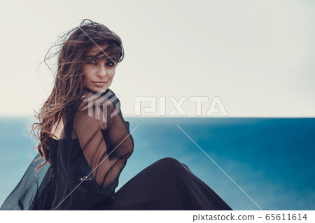 Portrait of beautiful young lady. Outdoors. Smoky 65611614