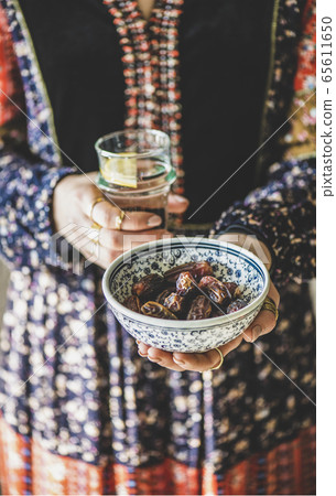 Woman holding dates and water for Ramazan Iftar Woman holding dates and water for Ramazan Iftar 65611650