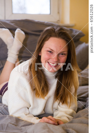 Young woman in knitted sweater and bikini in bed Young woman in knitted sweater and bikini in bed 65612026
